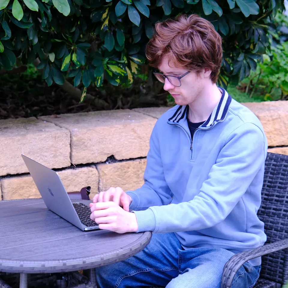 Jak working on his laptop outdoors in Milton Keynes